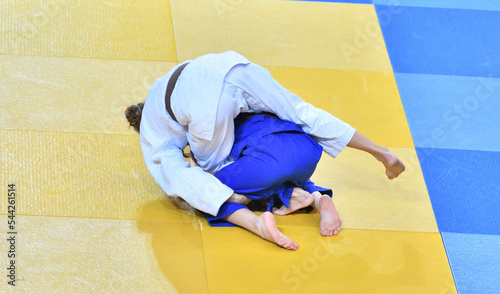 Fighter girls in judogi compete in judo on the tatami