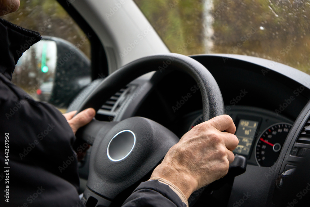 Naklejka premium Old man hands holding steering wheel, close-up