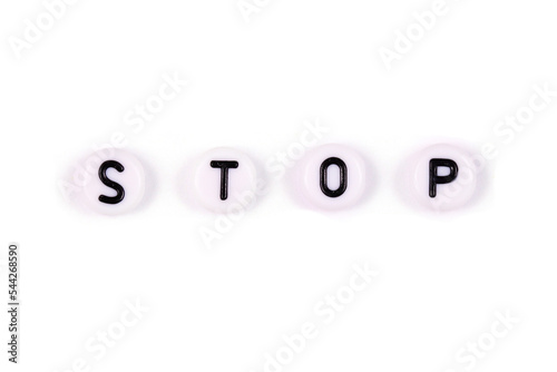 Stop. inscription from white beads on a white background. Copy space, top view