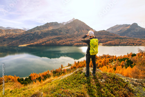Man observes autumn landscape at a mountain lake photo