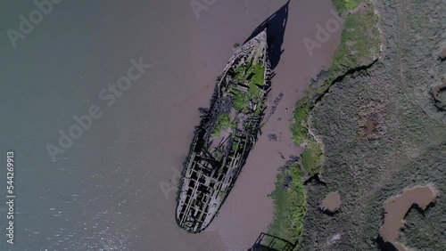 Drone Ascending Over Ruined Ship In Salt Marshes At Tollesbury Marina, Essex, United Kingdom. Aerial Rotating photo