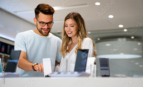 Wallpaper Mural Happy young people buying new smartphone in mobile shop. Technology device shopping concept Torontodigital.ca