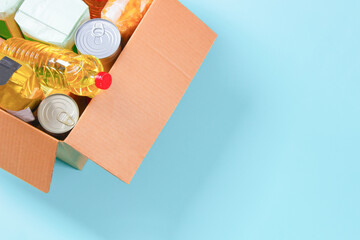 Cardboard box full of grocery products. Donation, charity, food bank, help for low income, poor families, migrants, refugees, homeless