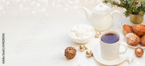 Winter, Christmas, New Year decoration composition, concept, background. White Mug, cup of hot tea, coffee, meringue. Christmas lights. Christmas mood morning. Xmas greeting card. Banner.
