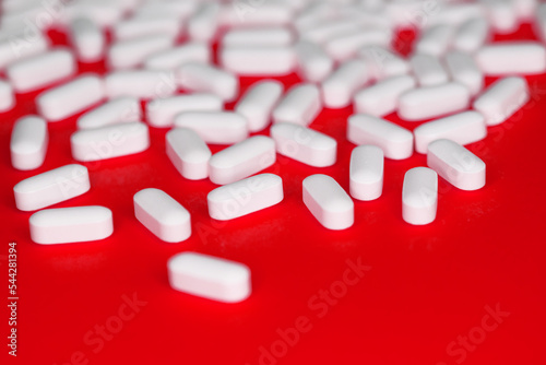 Medcine white pills aspirin om a red background