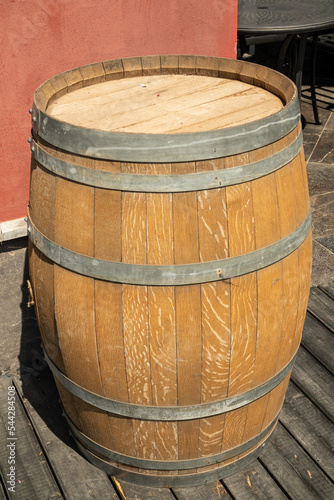 A large wooden barrel stands on the street near the building as a facade decoration.