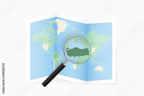 Enlarge Turkey with a magnifying glass on a folded map of the world.