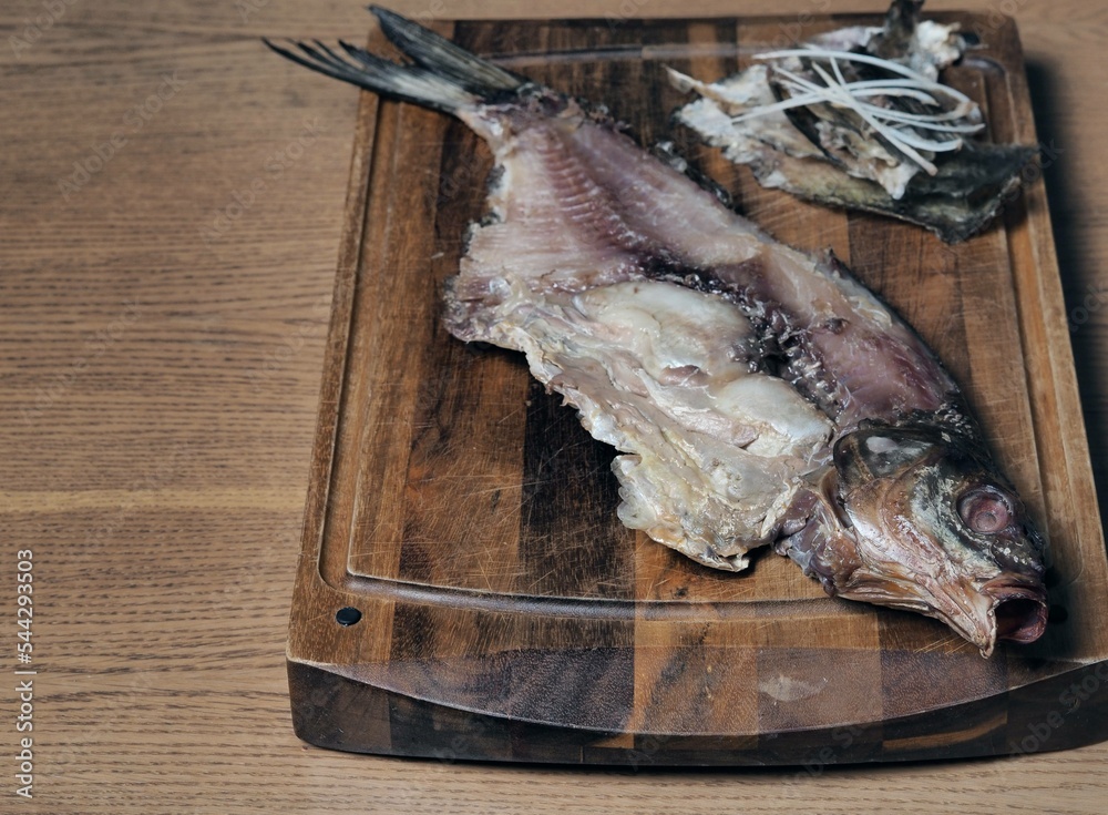 Half of the naked skeleton of a dried large bream lies on a kitchen ...