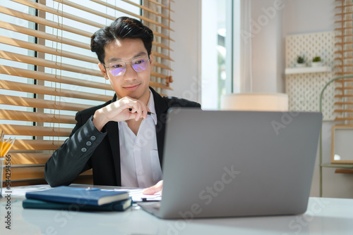 Focused handsome businessman working with computer at bright office..