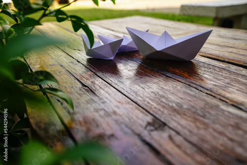Origami  white paper boat isolated on a wooden floor.  Paper boats mean walking.  feeling of freedom  leadership