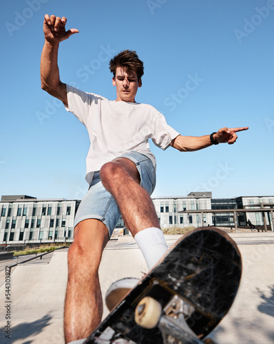 Fototapeta Naklejka Na Ścianę i Meble -  Skateboard, city and sports with a man outdoor in summer for recreation or fun while skating alone. Street, skater and energy with a young male skateboarding or riding a board in an urban town