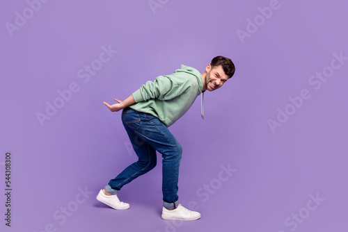 Full size photo of handsome young man carry back heavy object stressed wear trendy gray isolated on violet color background photo