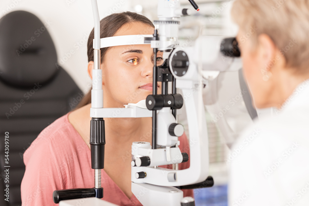 Eye, optometrist and eye exam in ophthalmologist office with optical machine to examine vision weak iris, pupil or lens of eyeball. Woman, optical clinic test and professional optician eye care test Eye, optometrist and eye exam in ophthalmologist office with optical machine to examine vision weak iris, pupil or lens of eyeball. Woman, optical clinic test and professional optician eye care test