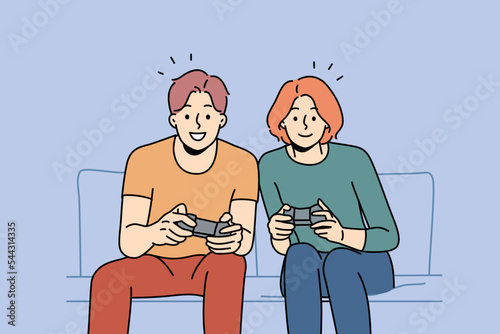 Smiling couple sit on sofa at home playing video game together. Happy man and woman have fun enjoy videogame with controllers. Vector illustration. 