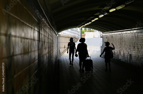 Mother and two kids passing through a tunnel in their travel. 