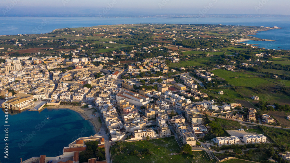 Aerial panoramic view at sunset on the island of Favignana. It's an Italian island belonging to the archipelago of the Aegadian islands, in Sicily, Italy. On background there is the Sicily island.
