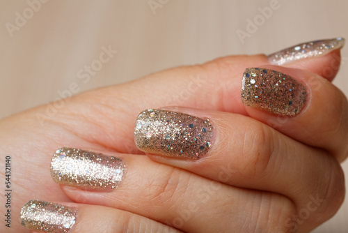 Closeup woman nail with fresh glitter manicure on the black background