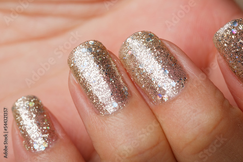 Closeup woman nail with fresh glitter manicure on the black background