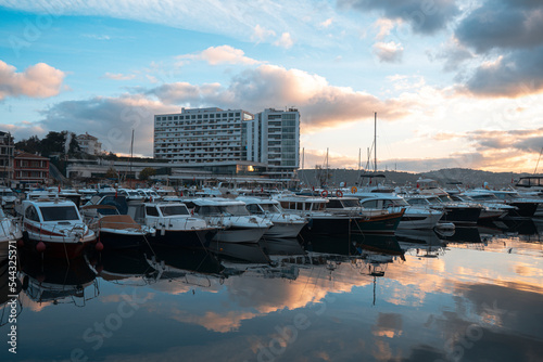 Sailboats at Tarabya yacht marina in Istanbul. Reflection of yachts and hotel. Blue sky and natural white clouds