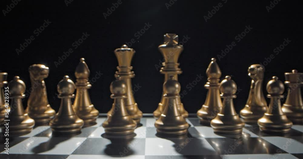 Cinematic dolly in between chess pieces on board that's set up, gold vs silver Cinematic dolly in between chess pieces on board that's set up, gold vs silver