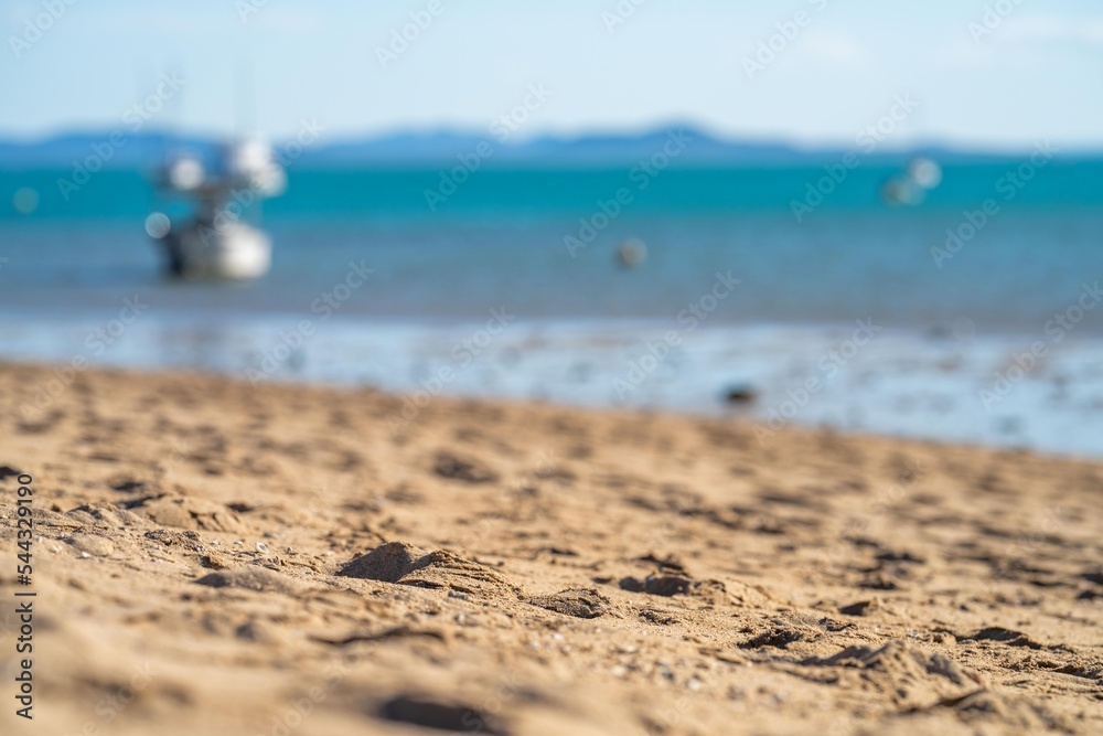 tourists on holiday at a tropical beach in the tropics with boats and yachts