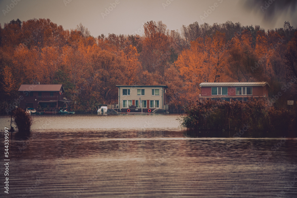 Houses on the river in autumn landscape