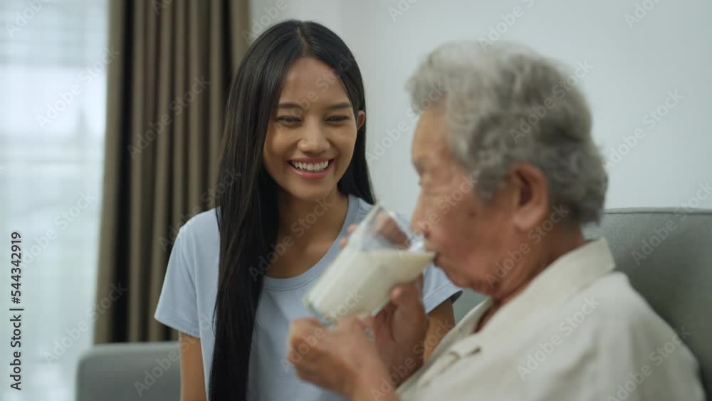 Portrait Asian senior elderly couple drinking milk. Young woman taking care of senior woman at home. Portrait Asian senior elderly couple drinking milk. Young woman taking care of senior woman at home.