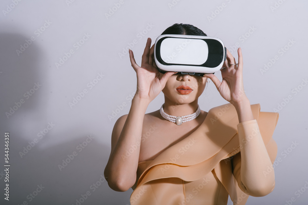 Portrait  of Asian woman wearing a using virtual reality headset. Studio portrait. VR, future, education online, gadgets, technology,  studying, video game concept free copy space.