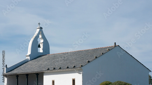 Pequeña iglesia con tejado de pizarra y campana