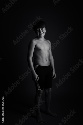 Happy boy posing with bathing suit, black and white studio photography