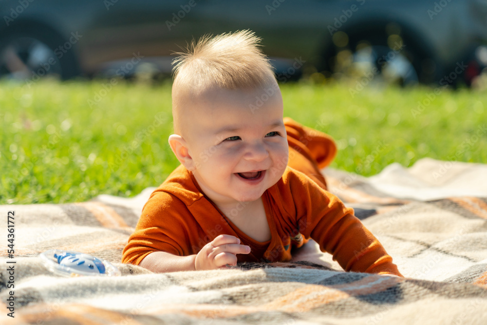 Cute baby lying on the blanket on summer grass. Child outdoor. Cute baby lying on the blanket on summer grass. Child outdoor.