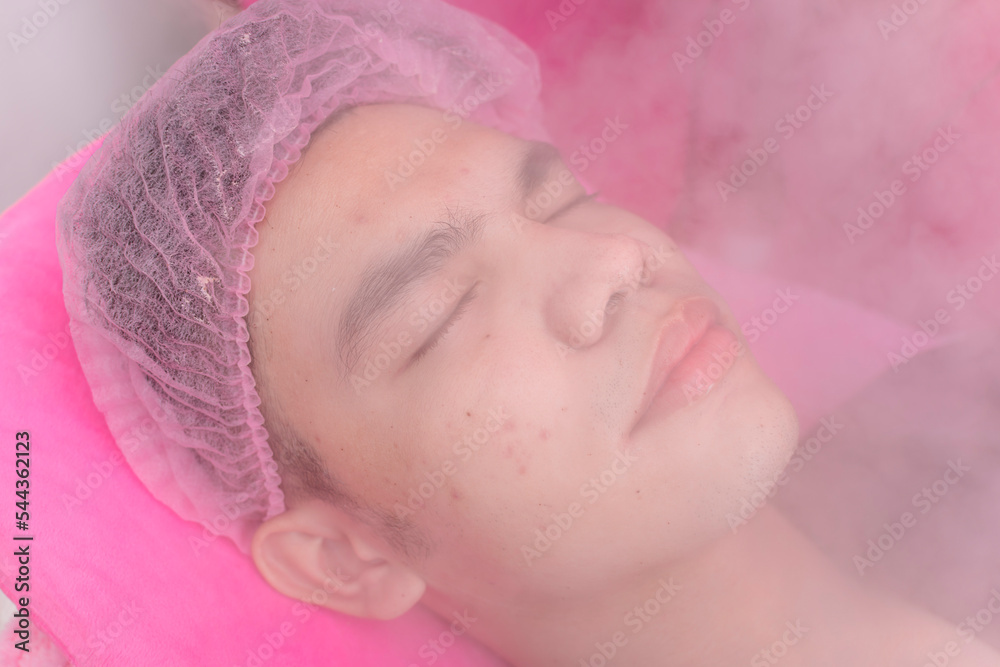 A male customer undergoes a steaming treatment to open up the skin