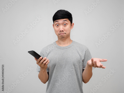 Man grey shirt holding smart phone show hand up gesture i don't know,Man confused isolated