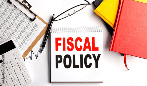 FISCAL POLICY text on notebook with clipboard and calculator on white background photo