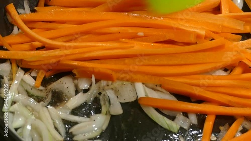Frying onions with carrots in the pan