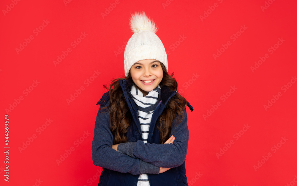 Fototapeta premium positive smiling kid with curly hair in hat. teen girl on red background.