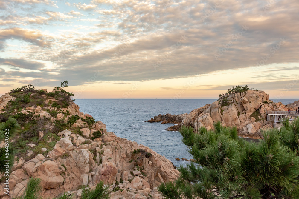 Red rocky coastline overlooking the ocean at Daewangam Park in Ulsan South Korea during a colorful golden sunset