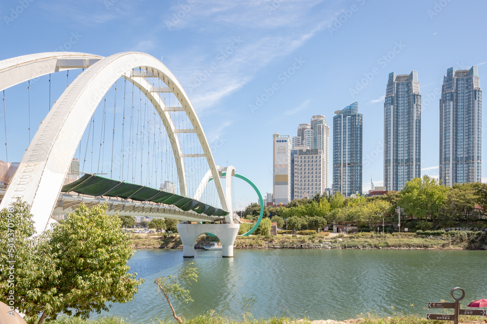 White bridge over a river at Taehwagang park and city building view of downtown Ulsan South Korea