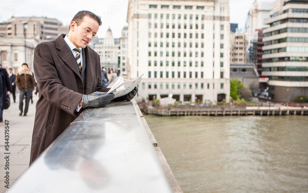 London Professionals, City Gent. A smartly dressed business man catching up with the latest financial news. From a series of related images. London Professionals, City Gent. A smartly dressed business man catching up with the latest financial news. From a series of related images.