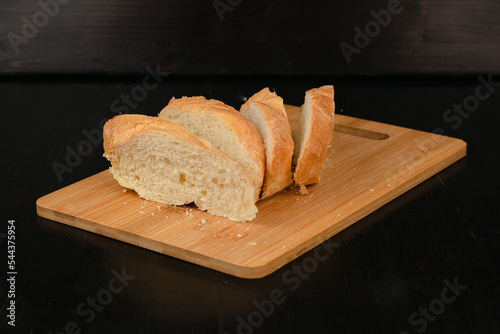 Sliced white bread lies on a cutting board on a wooden background