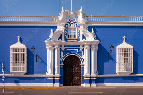 Traditional blue architecture with white painted windows railings and adorned main door, Trujillo, Peru photo