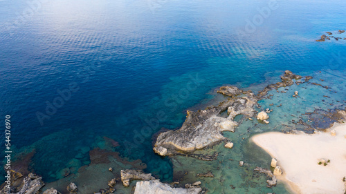 Aerial view on the blue and turquoise waters of the Favignana island in Sicily, Italy. The sea is clean and flat and the coast is rocky.