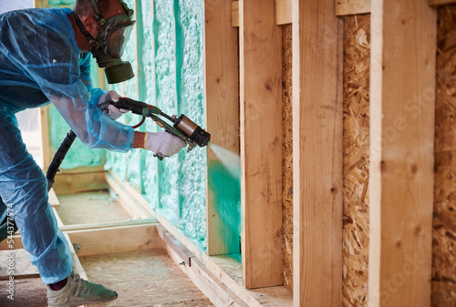 Canvas Print Male builder insulating wooden frame house