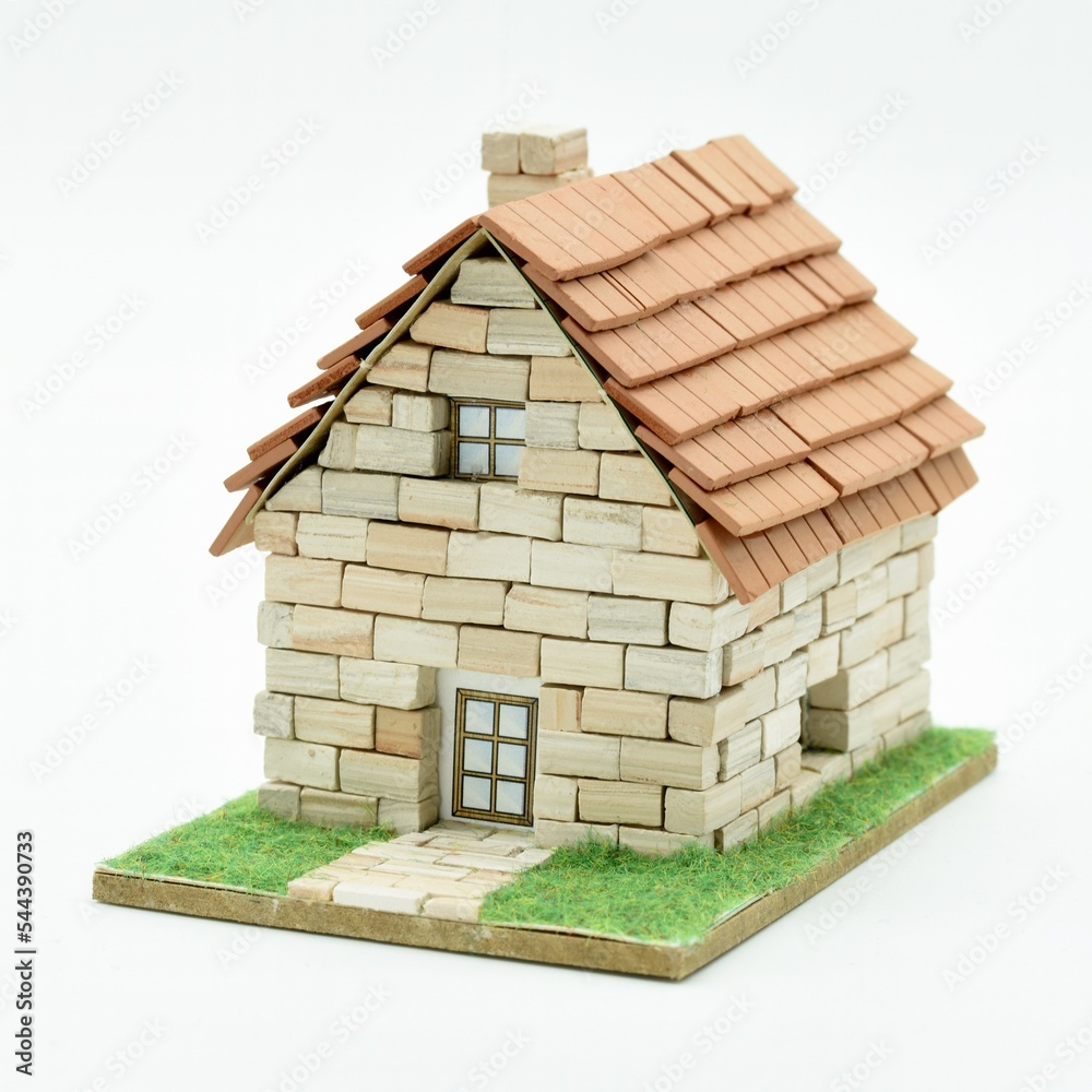 Casita hecha de ladrillos de piedra en miniatura, aislado en blanco Stock  Photo