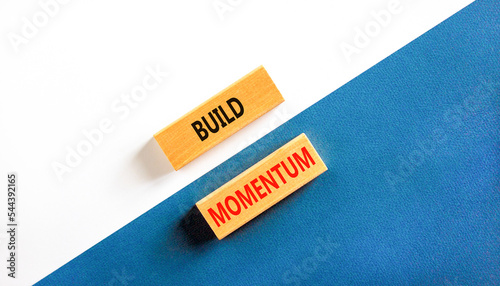 Build momentum symbol. Concept words Build momentum on wooden blocks. Beautiful white and blue background. Business and build momentum concept. Copy space.