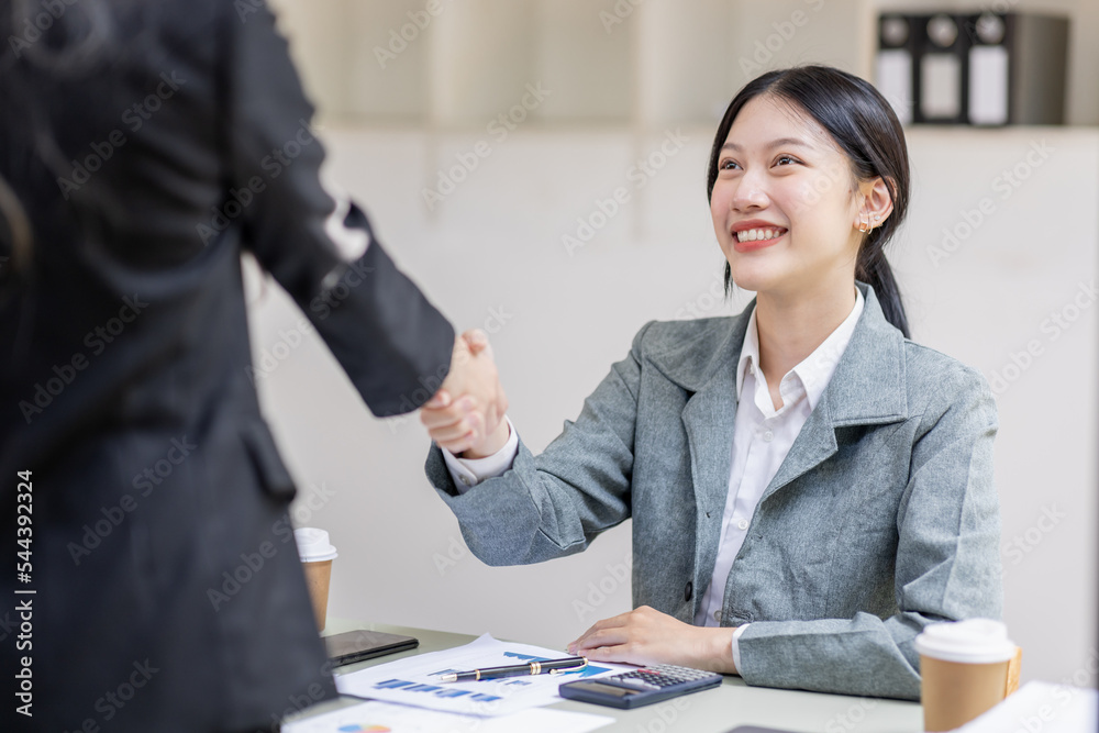 Two young asia business woman shaking hands successful making a deal, business woman handshake. Business partnership meeting handshake concept. Two young asia business woman shaking hands successful making a deal, business woman handshake. Business partnership meeting handshake concept.