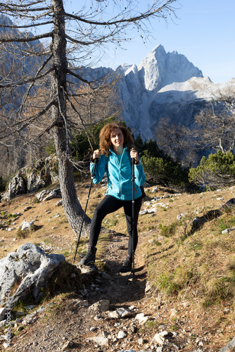 Smiling Curly Hair Toothy Smile Mid Adult Woman Hiker Looking at Camera in Alpine Autumn Environment 