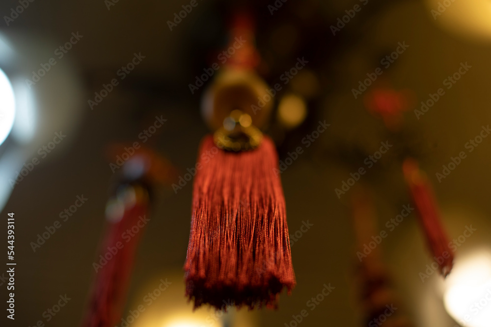 Red cloth hanging from ceiling. Thread brush. Interior decoration. Indian Decoration. Details of light in room.