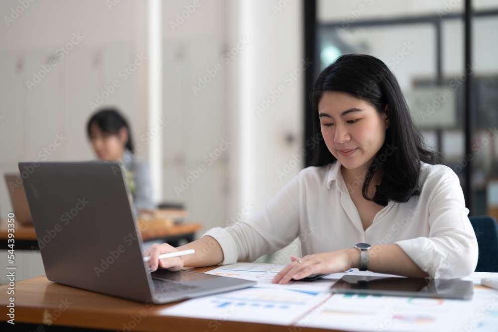Portrait Of Attractive Asian Businesswoman Working On Laptop for marketing plan. Portrait Of Attractive Asian Businesswoman Working On Laptop for marketing plan.