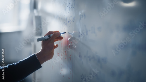 Macro Shot of a Blue Marker Pen Being Held with a Hand. Teacher Writing Equations on a Whiteboard with Mathematical Formulas. Higher Education in University of Technology Concept.